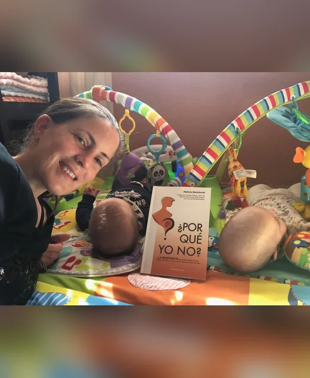 Madre junto a sus bebés gemelos y un libro