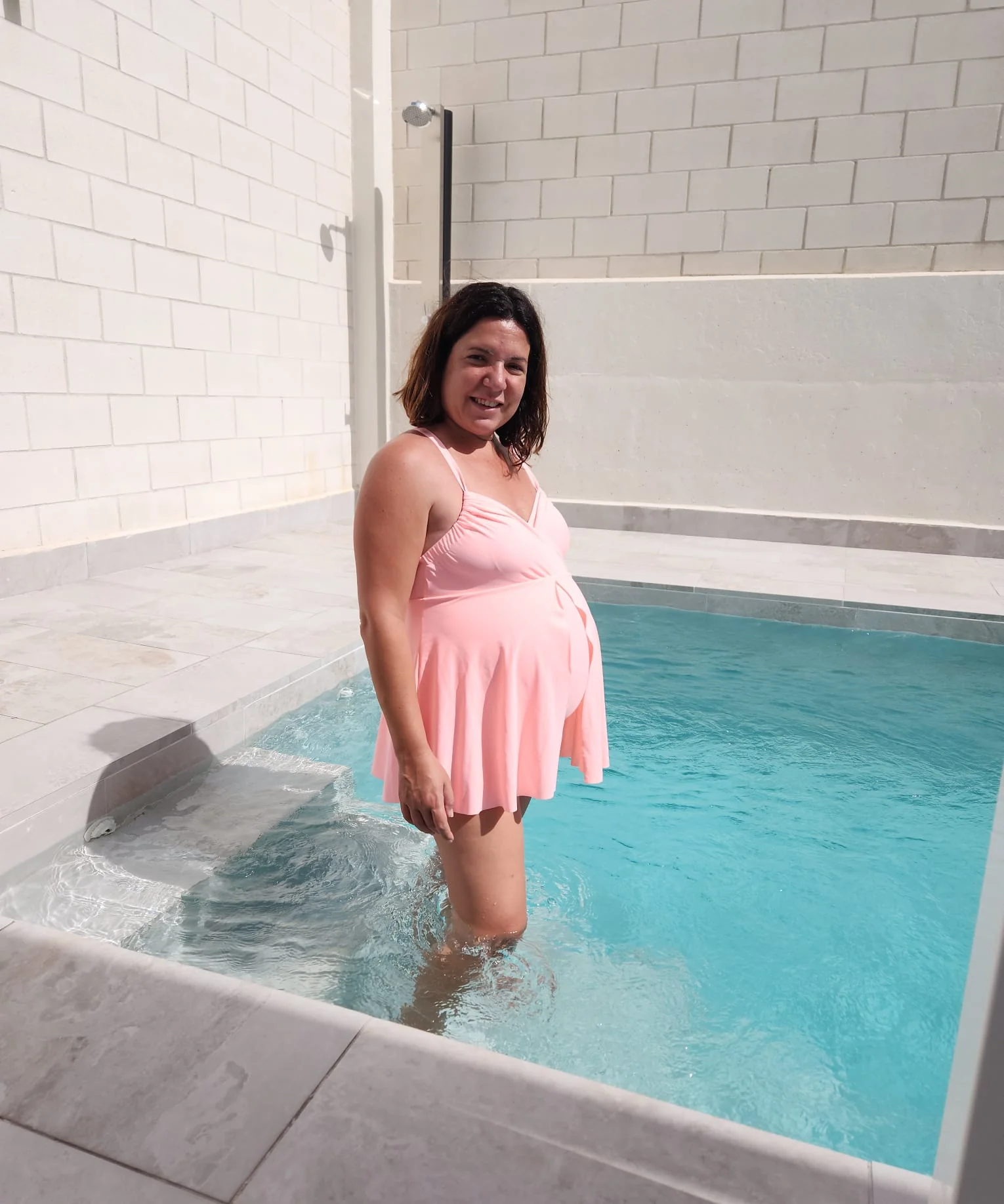 Mujer embarazada posando en una piscina